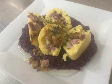 Naše bramborové knedlíky plněné uzeným masem, červené zelí, osmažená cibulka